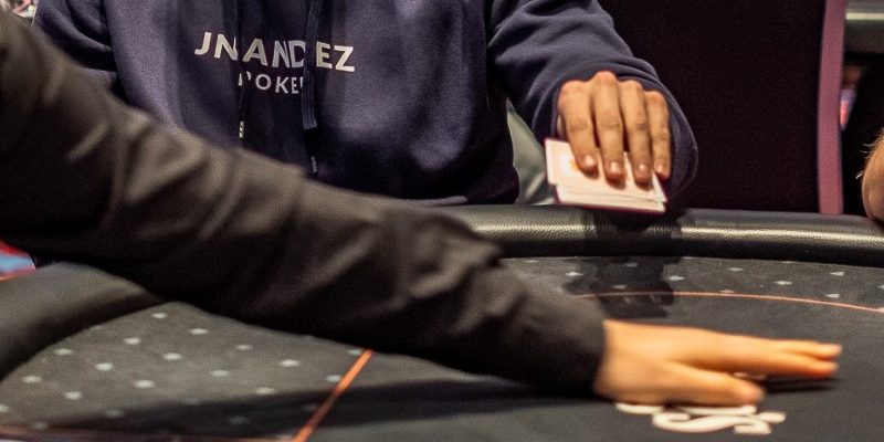 A poker player folding his holecards.