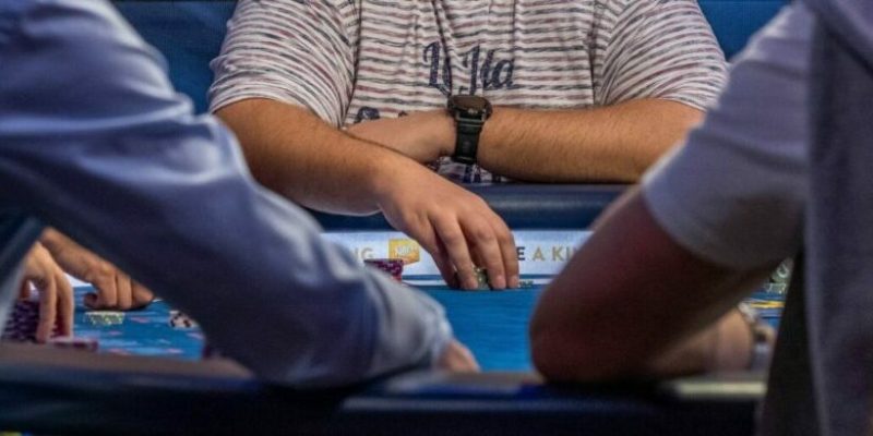 A poker player making a bet at a live poker table.