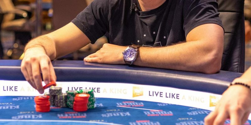 A poker player making a preflop call at a live PLO table.