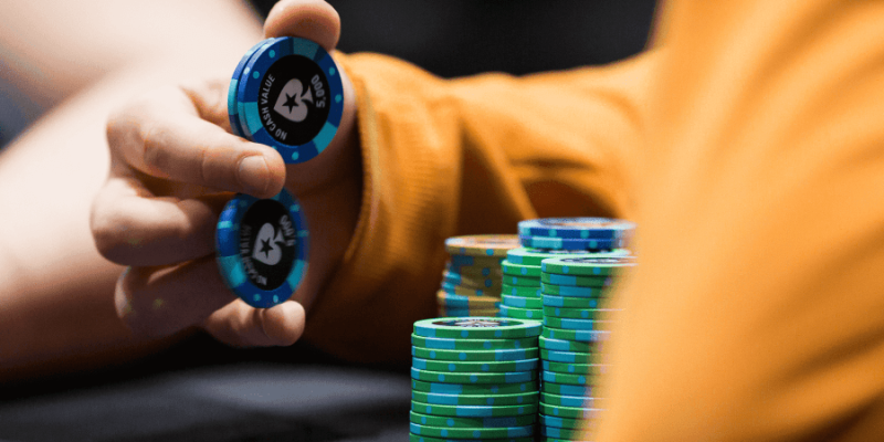 A poker player balancing poker chips in his hands.