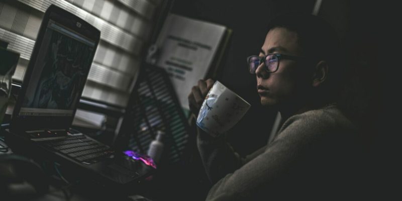 A person studying poker while drinking coffee.
